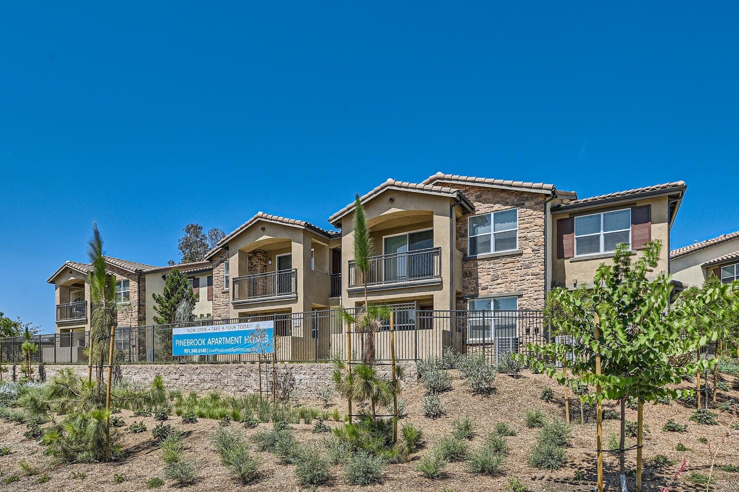 Front exterior of Pinebrook Apartment Homes with landscaping